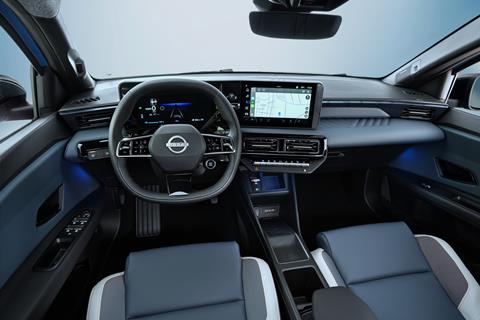 full dashboard view of cockpit from driver POV showing steering wheel. driver focused infotainment, front seats, and blue ambient lights below the dashboard. Google maps navigation on screen